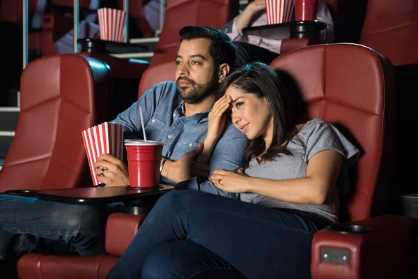 Woman holding boyfriends arm at cinema — Stock Photo, Image