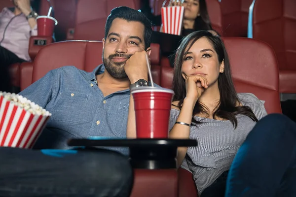 Bored couple watching a movie at cinema