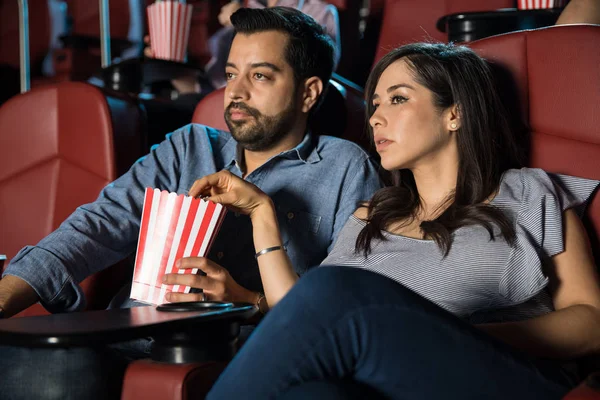 Couple eating popcorn at cinema — Stock Photo, Image