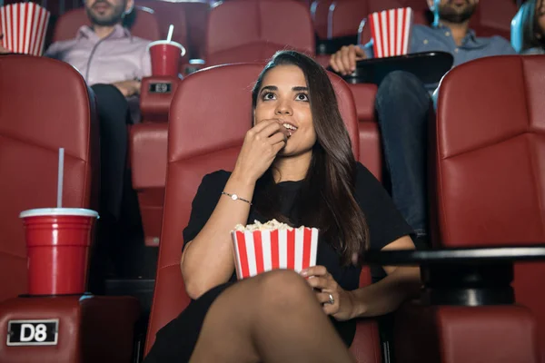 Jeune femme regardant un film au cinéma — Photo