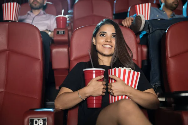 Smiling woman holding snacks at cinema — Stock Photo, Image