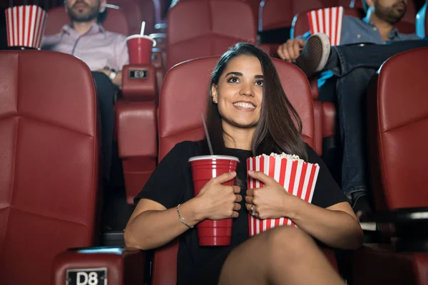 Mulher sorridente segurando lanches no cinema — Fotografia de Stock