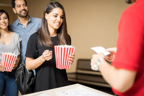 Mujer mostrando entrada a empleado de cine — Foto de Stock