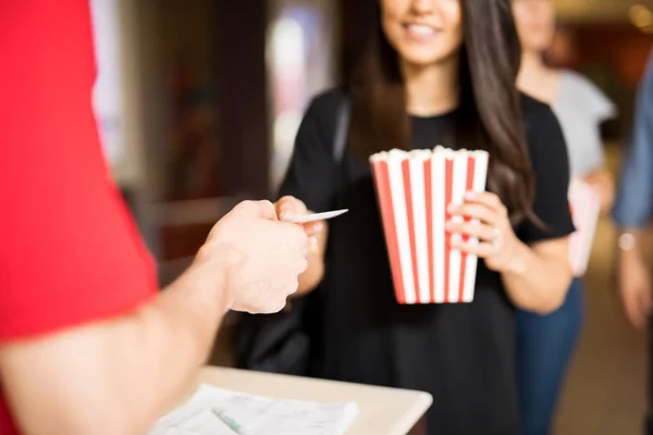 Woman handing tickets to cinema worker