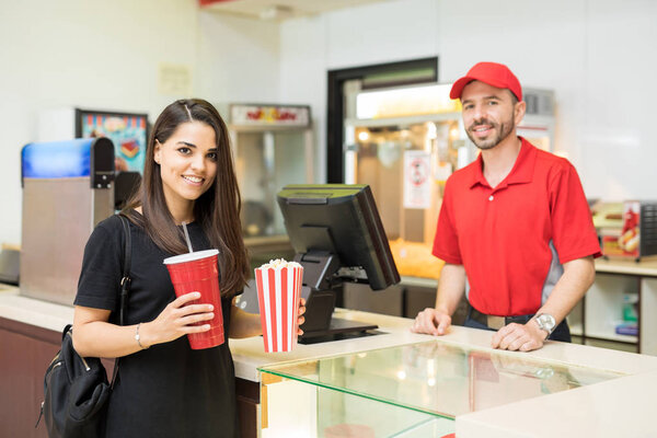 Woman holding popcorn and soda
