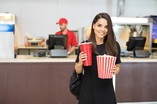 Woman carrying popcorn and soda