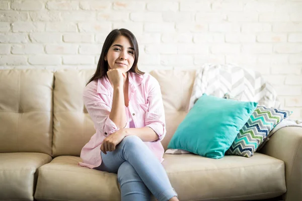 Spansktalande kvinna sitter i en soffa — Stockfoto