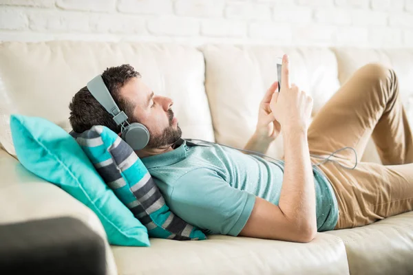 Muž se sluchátky v obývacím pokoji — Stock fotografie