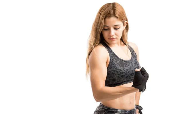 Woman in sporty outfit flexing arm — Stock Photo, Image