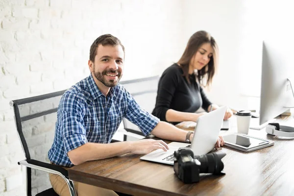 Man editing photos with a coworker — Stock Photo, Image