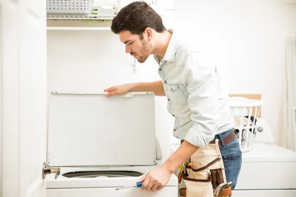 Handyman inspecionando uma máquina de lavar — Fotografia de Stock