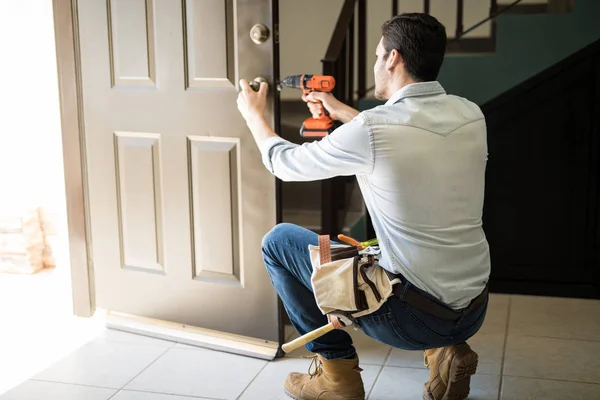 Jeune homme fixant une serrure de porte — Photo