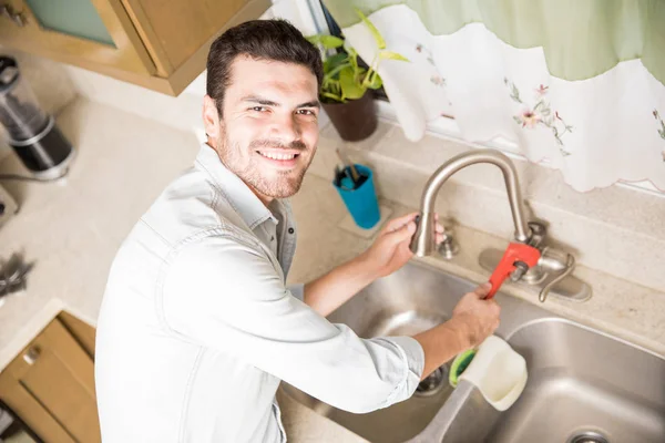 Glücklicher Handwerker repariert einen undichten Wasserhahn — Stockfoto