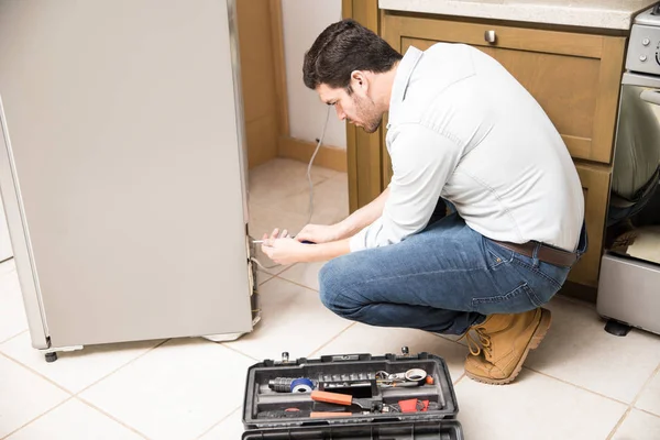 Erkek elektrikçi bir buzdolabı tamiri — Stok fotoğraf