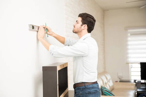 Man using level and marking a wall — Stock Photo, Image