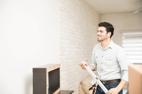 Homme à tout faire installant une étagère — Photo