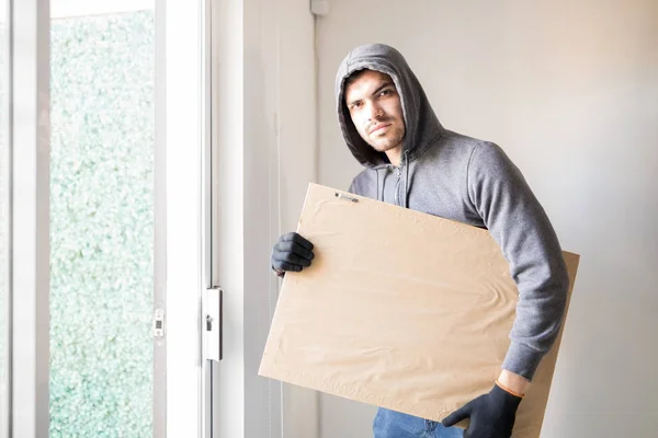 Male robber stealing a piece of art — Stock Photo, Image