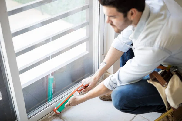 Applying some sealant on a door — Stock Photo, Image