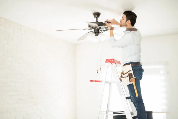 Eletricista fixando um ventilador de teto — Fotografia de Stock