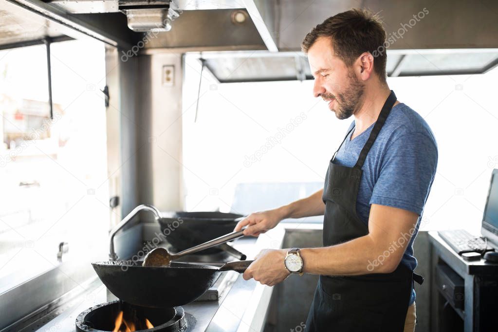Male chef cooking in a food truck