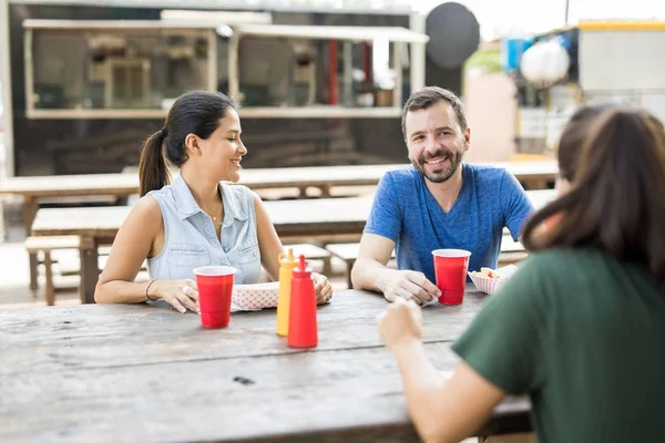 Amigos comiendo frente a un camión de comida — Foto de Stock