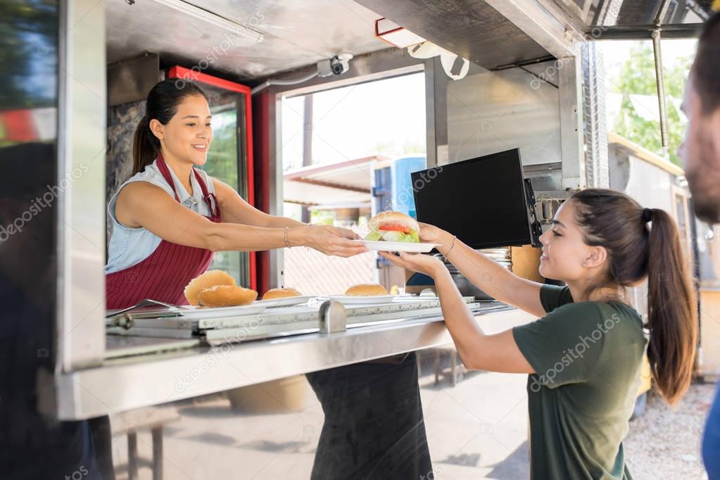 Woman serving food to customer