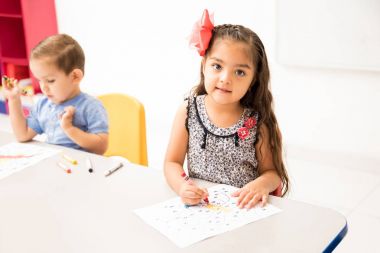 Okulda bir boyama etkinliği yapmak güzel bir İspanyol okul öncesi öğrenci portresi