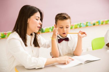 Erkek okul öncesi öğrenci üniforma ve onun öğretmen sınıfta bazı yardım alma