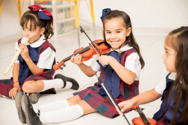Okul öncesi içinde keman ve sahip eğlenceli oynamak için öğrenme nasıl şirin bir Latin kız portresi
