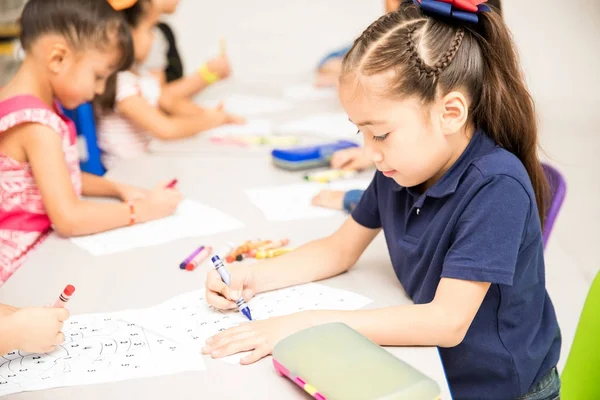 幼児教室のグループの残りの部分との色の活動を行う少女の肖像画 — ストック写真