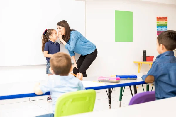 유치원 교사는 교실에서 게임을 학생의 속삭이는 — 스톡 사진