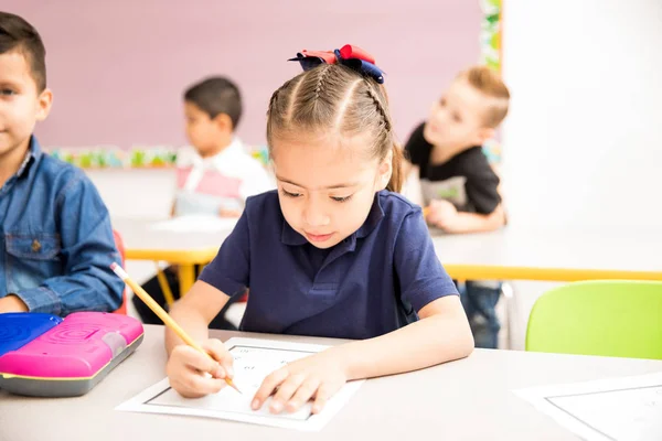 教室でいくつかの数学の演習をやって忙しい幼稚園女の子 — ストック写真