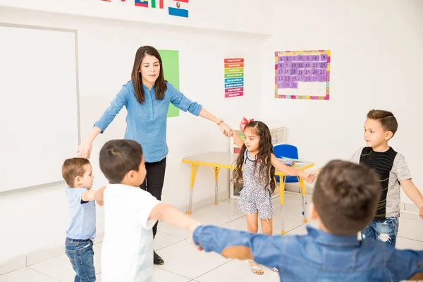 Maestra Preescolar Cogida Mano Con Sus Estudiantes Haciendo Círculo Aula —  Fotos de Stock