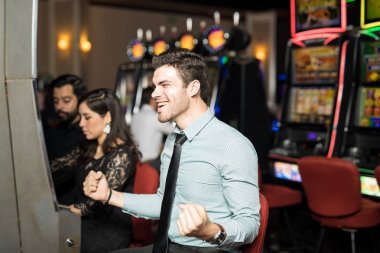 Bir casino slot makinesidir ikramiye isabet sonra heyecanlı ve kutluyor arayan İspanyol yakışıklı genç