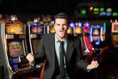Bir casino slot makinesidir ikramiye isabet hakkında heyecanlı seyir elbiseli çekici genç adam
