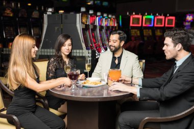 Yemek yerken ve bir casino restoranda bir şeyler sahip İspanyol arkadaş grubu