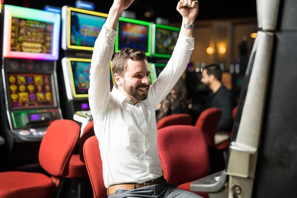 幸せと興奮のカジノでのスロット マシンでジャック ポットを打つ良い探している男 — ストック写真