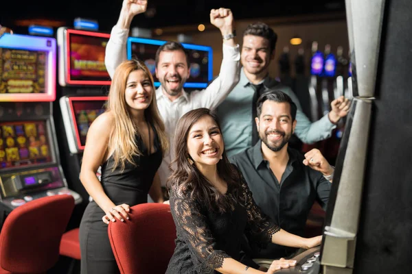 彼らはカジノのいくつかのスロットを再生し 彼らはいくつかのお金を獲得しながら一緒に楽しい時間を過ごす 人の友達グループ — ストック写真
