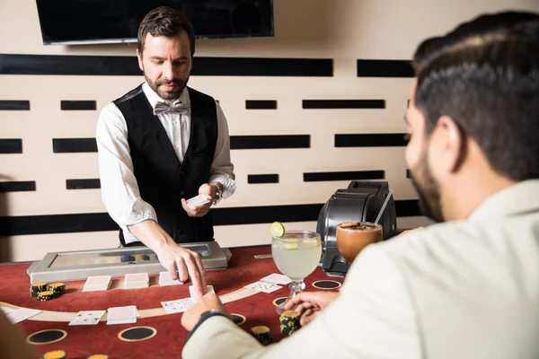 ハンサムな若い男がカジノでブラック ジャックのゲームの中にカードを扱って — ストック写真