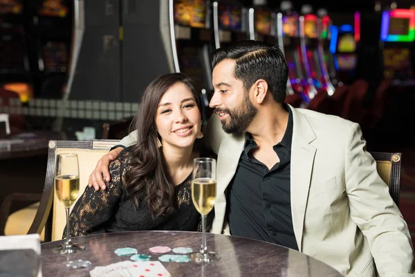 漂亮的年轻情侣调情和有趣的日期在赌场与老虎机在后台 — 图库照片