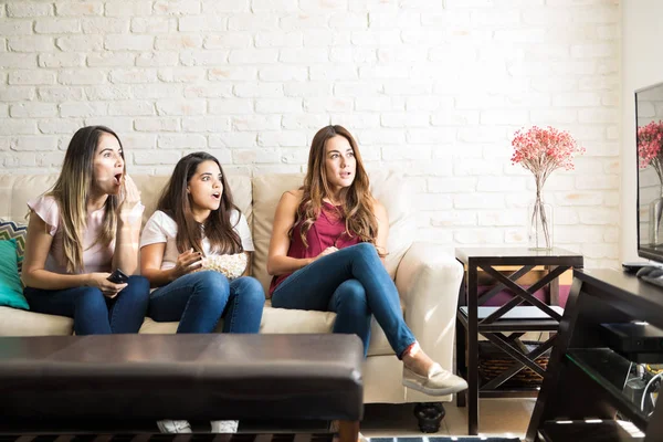 Mirando sorprendido sobre un programa de televisión — Foto de Stock