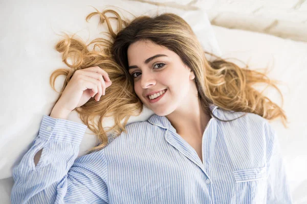 Щаслива жінка розслабляється на ліжку — стокове фото