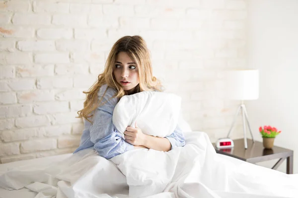Güzel kadın yatakta korkmuş seyir — Stok fotoğraf