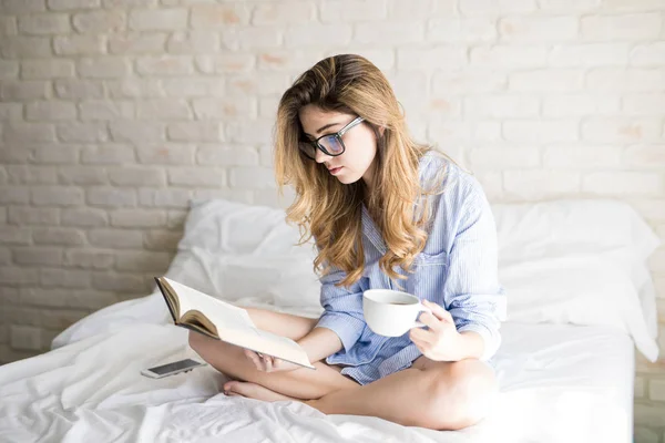 Čtení knihy v posteli — Stock fotografie
