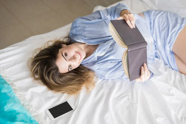 Spät im Bett bleiben, um ein Buch zu lesen — Stockfoto