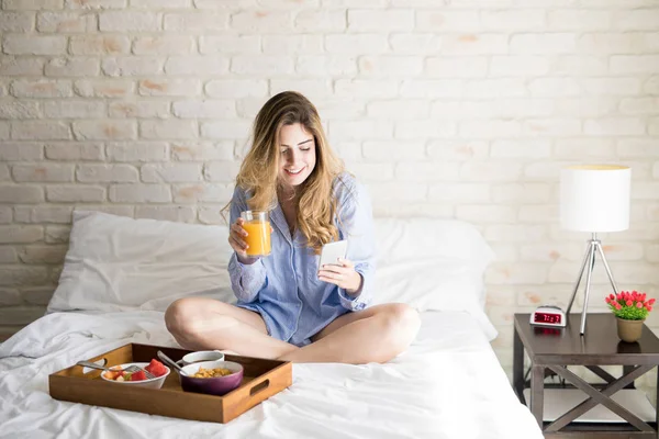 Utilizzando uno smartphone durante la colazione — Foto Stock