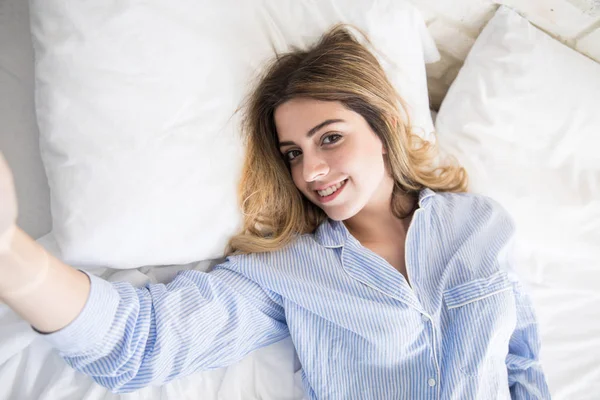 Tomándose una selfie en su cama —  Fotos de Stock