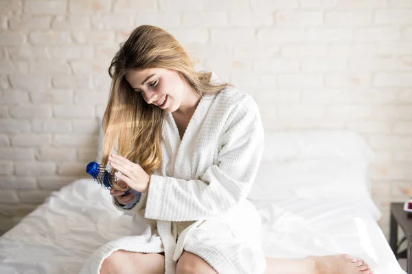Kadın yatakta saçları fırçalama — Stok fotoğraf