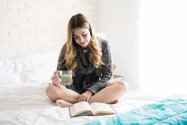 Gezellige meisje lezen en het drinken van thee — Stockfoto