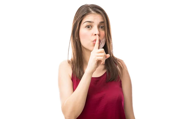 Woman holding finger to mouth — Stock Photo, Image